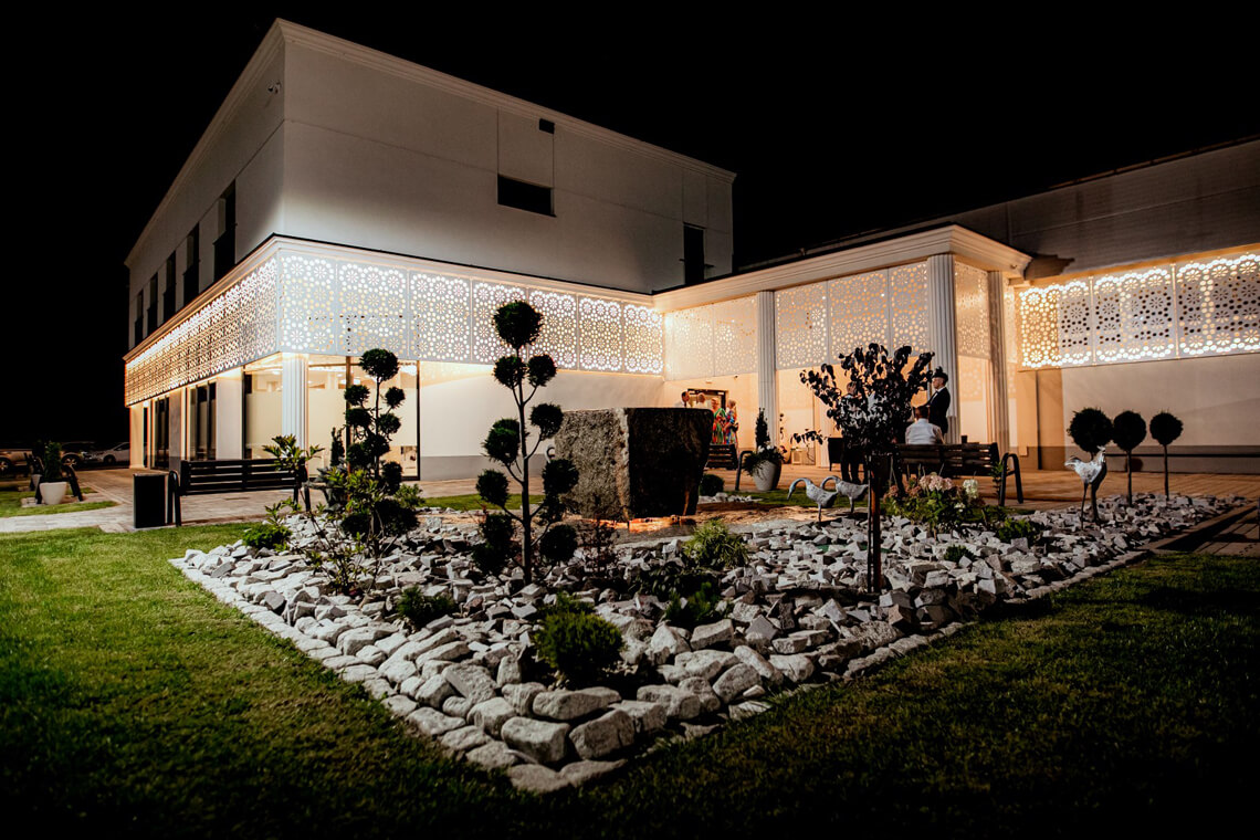 Oświetlony budynek sali weselnej Sting w Mszanie Dolnej nocą – widok zewnętrzny